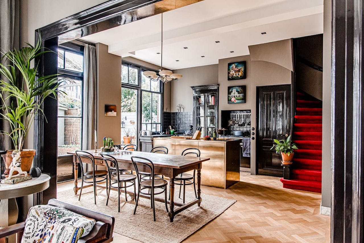 Blurred image of a dining room and kitchen.